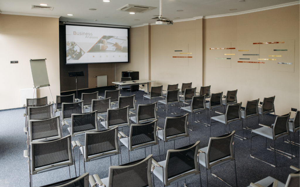 Dedicated home cinema featuring a ceiling-mounted projector, large projection screen, and surround sound speakers for a cinematic experience.