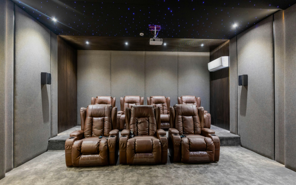 Dedicated home cinema with acoustic wall panels, bass traps, and sound absorption treatments improving clarity, dialogue, and surround sound performance.
