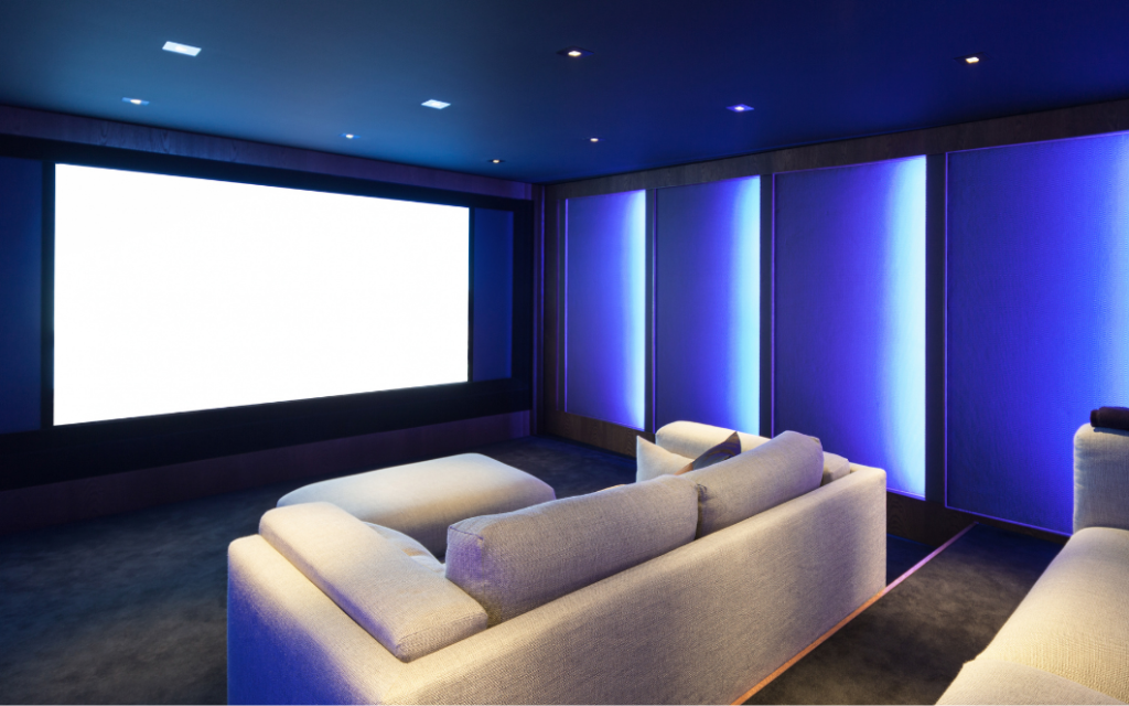 Custom home theatre interior showcasing acoustic wall treatments, integrated speakers, and cinema-style seating.