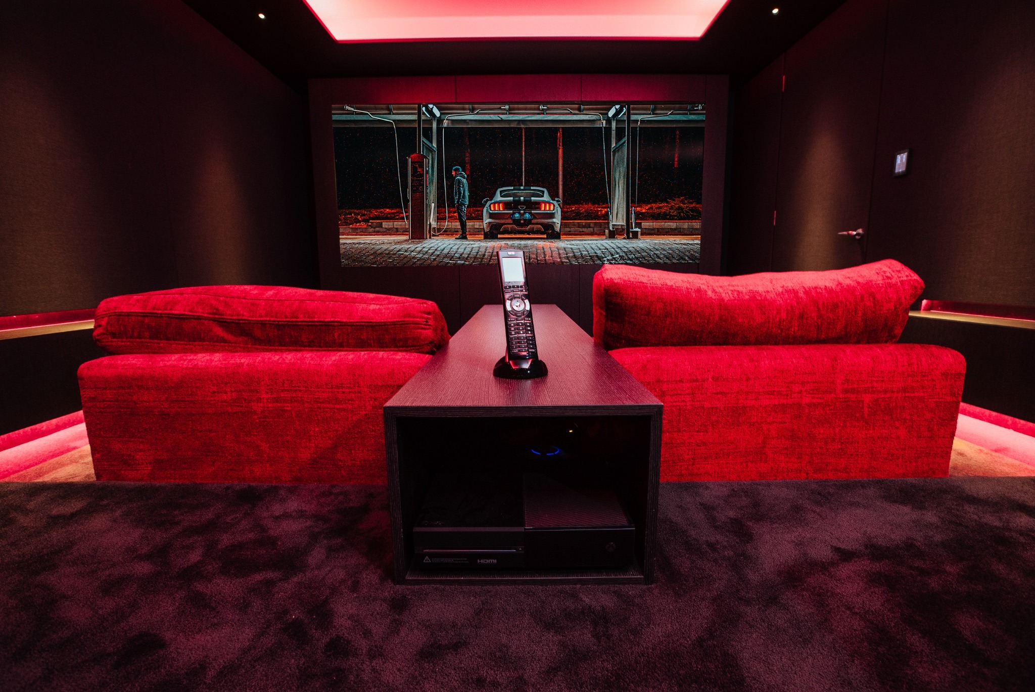 Reference-grade home cinema featuring concealed technology, acoustic treatment, and cinema-quality projection